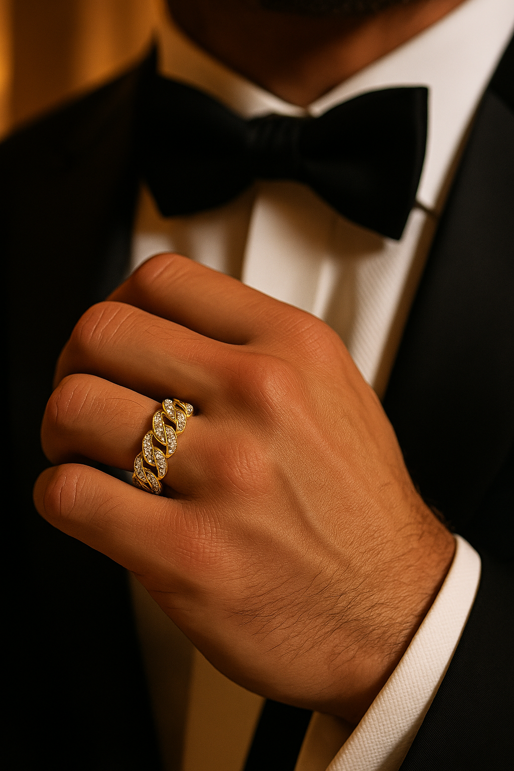 Hand wearing a gold ring with a tuxedo in the background