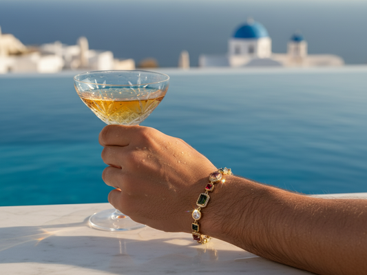 Hand holding a glass of white wine with a scenic background of a coastal town.