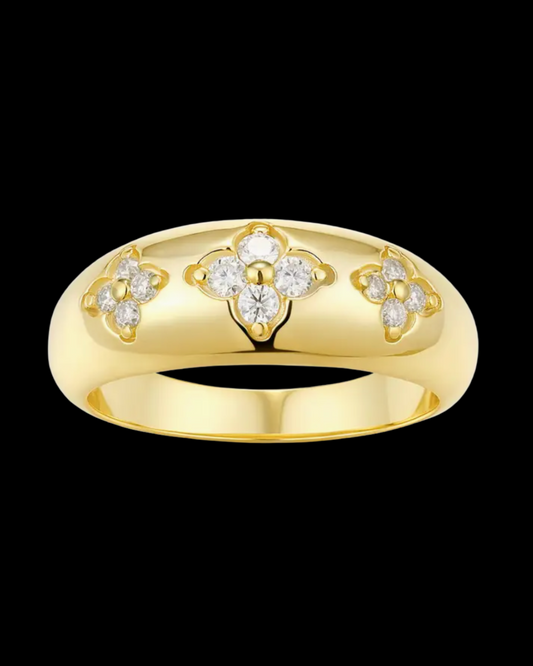 Gold ring with diamond floral designs on a black background