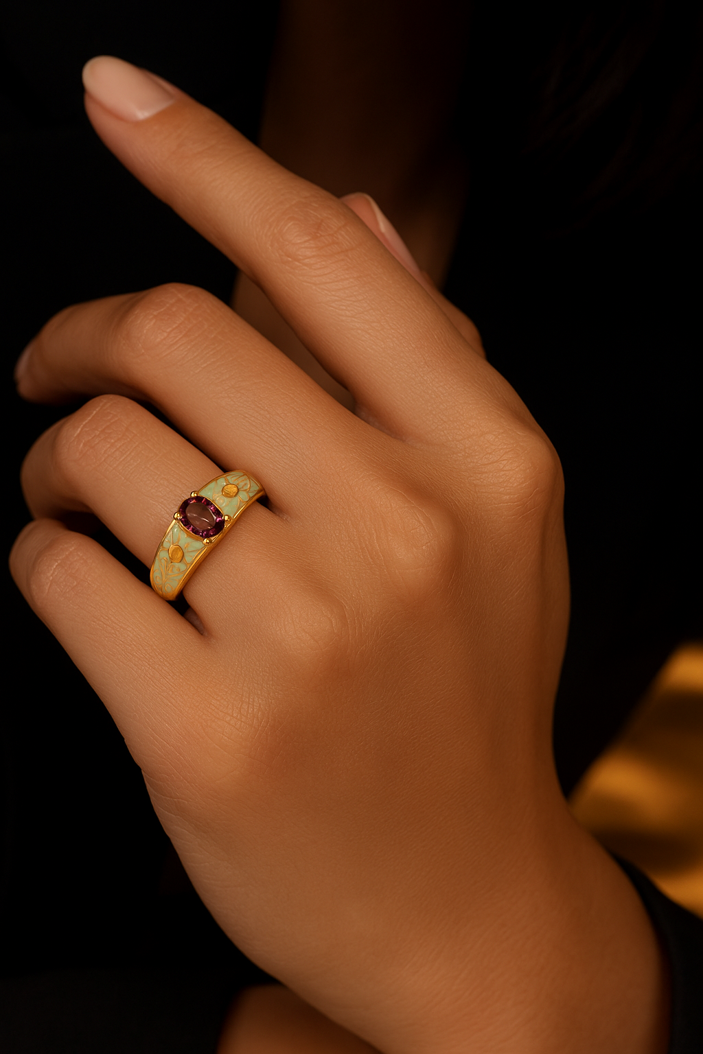 Close-up of a hand wearing a gold ring with a red gemstone on a dark background